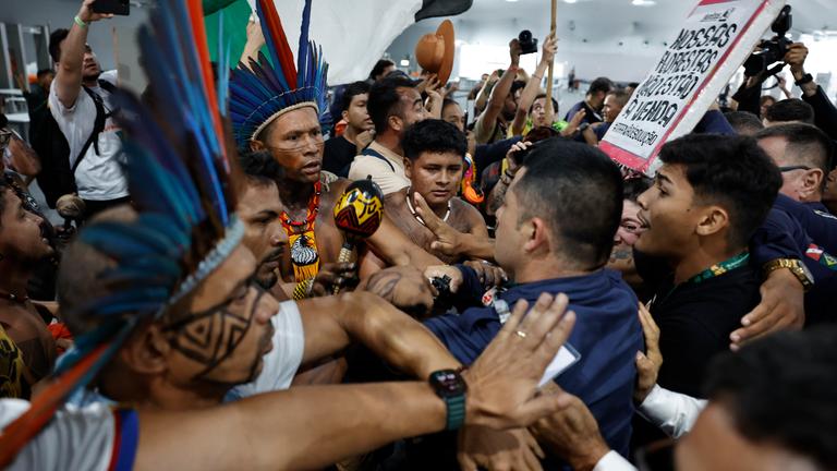 Demonstrierende geraten mit Sicherheitspersonal aneinander, draußen vor dem Gebäude, wo die UN-Klimakonferenz stattfindet.