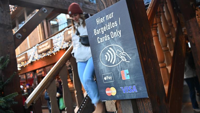 Schild vor einer Trempe von eime Restaurant: Cards only-Hier nur bargeldlos 