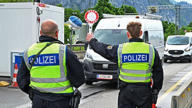 Grenzkontrolle: Polizisten halten an der Grenze einen weißen Transport an