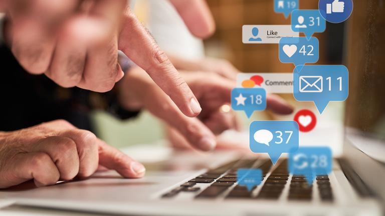 Finger auf Tastatur mit vielen Nachrichten Icons