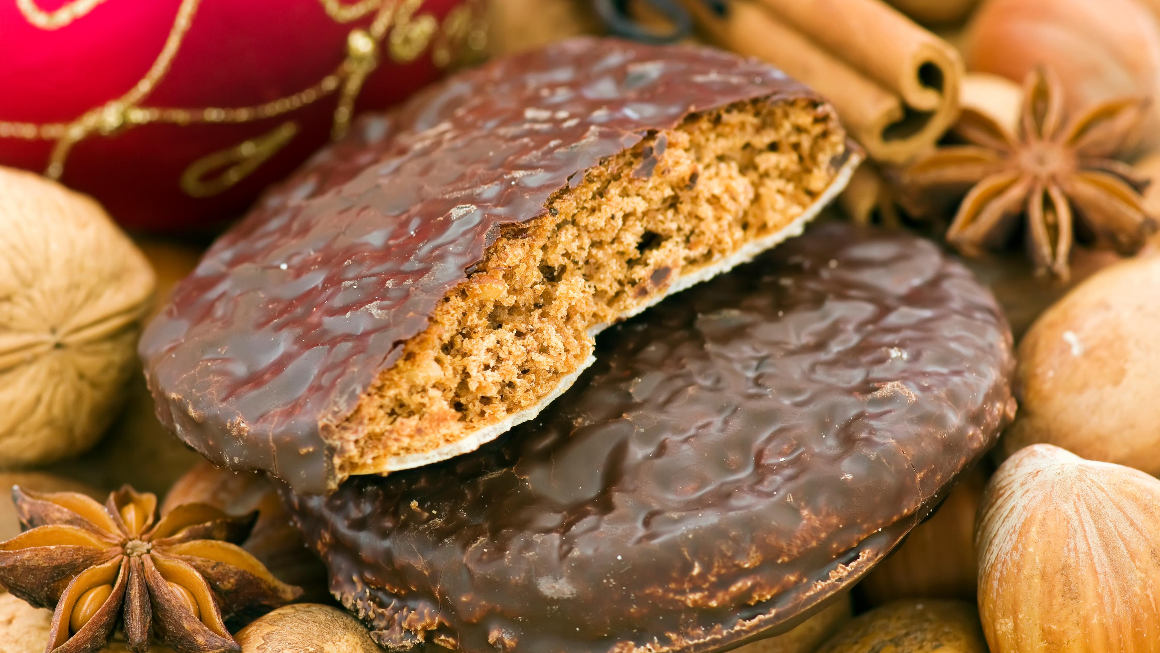 Weihnachts-Ingwerbread mit Nüssen, Zimt-Sticks und Baubles als Nahaufnahme