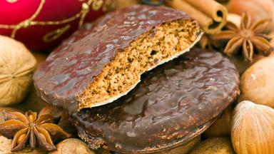 Weihnachts-Ingwerbread mit Nüssen, Zimt-Sticks und Baubles als Nahaufnahme