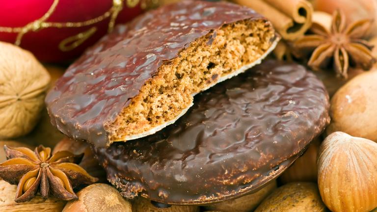 Weihnachts-Ingwerbread mit Nüssen, Zimt-Sticks und Baubles als Nahaufnahme