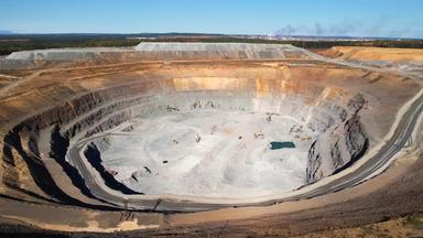 Ein aktiver Goldabbau-Steinbruch mit Industrieanlagen, Blick vom Rand des Steinbruchs.