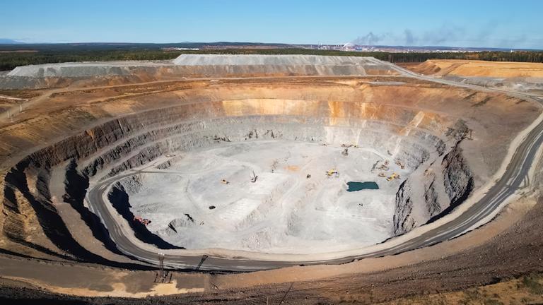 Ein aktiver Goldabbau-Steinbruch mit Industrieanlagen, Blick vom Rand des Steinbruchs.