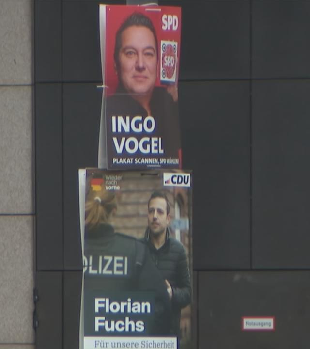 Ein SPD- und ein CDU-Wahlplakat hängen in Essen übereinander