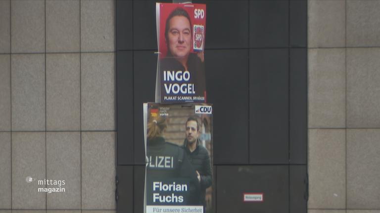 Ein SPD- und ein CDU-Wahlplakat hängen in Essen übereinander