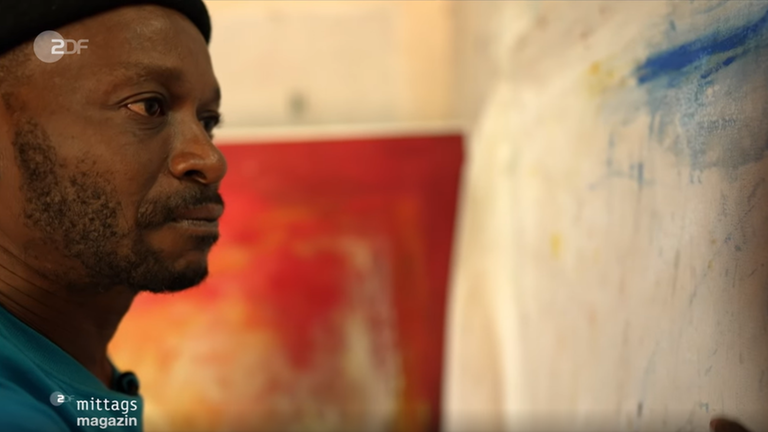 Künstler Nico Phooko vor einer Leinwand