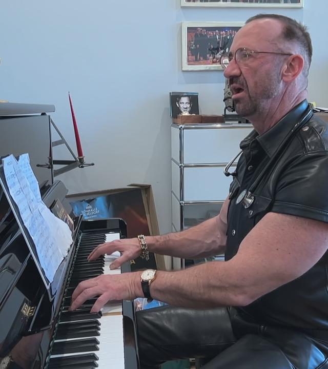 Allgemeinmediziner Matthias Heilein singend am Klavier in seiner Praxis