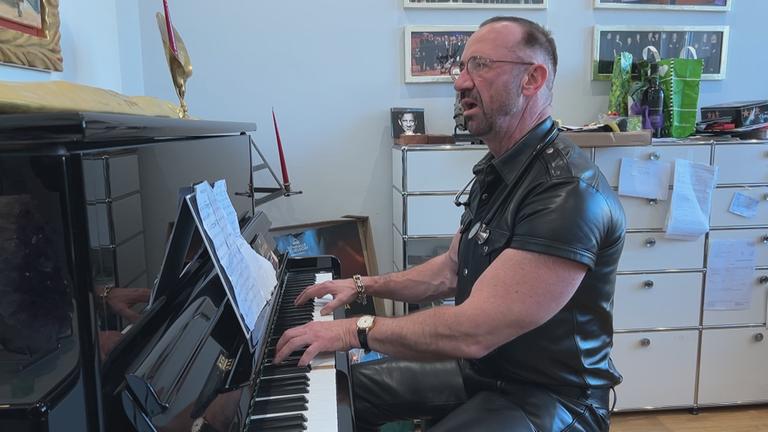 Allgemeinmediziner Matthias Heilein singend am Klavier in seiner Praxis