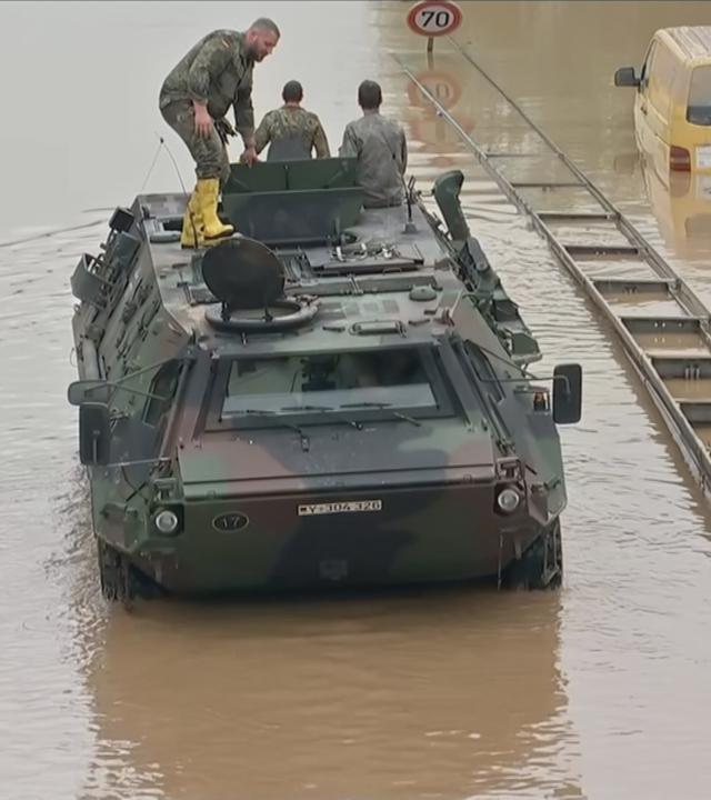 Bundeswehrfahrzeug im Hochwasser neben überfluteten Pkw
