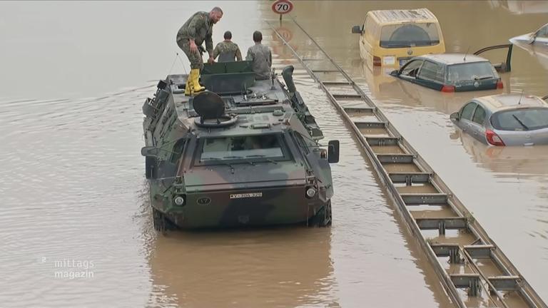 Bundeswehrfahrzeug im Hochwasser neben überfluteten Pkw