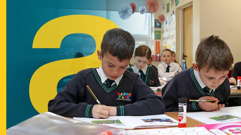 Britische Schüler sitzen an Tischen in Klassenraum