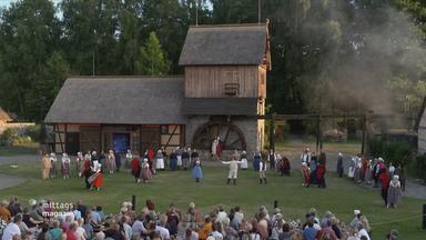 Darstellerinnen und Darsteller der Krabat-Festspiele vor der Schwarzen Mühle in Schwarzkollm