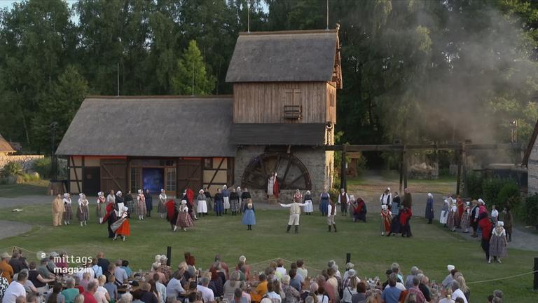Darstellerinnen und Darsteller der Krabat-Festspiele vor der Schwarzen Mühle in Schwarzkollm