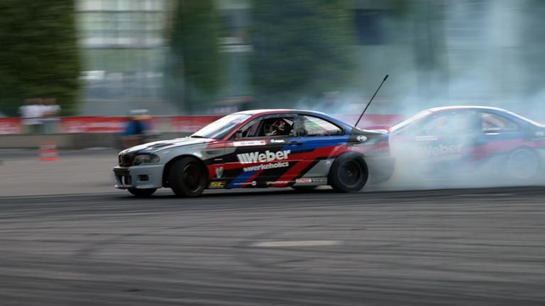 Tourensportwagen mit rauchenden Reifen bei einem Autorennen