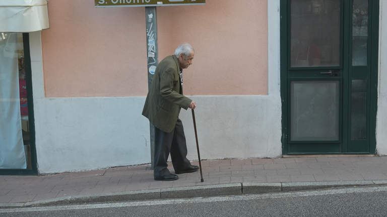 Ein italienischer alter Mann spaziert durch einen Ort auf Sardinien