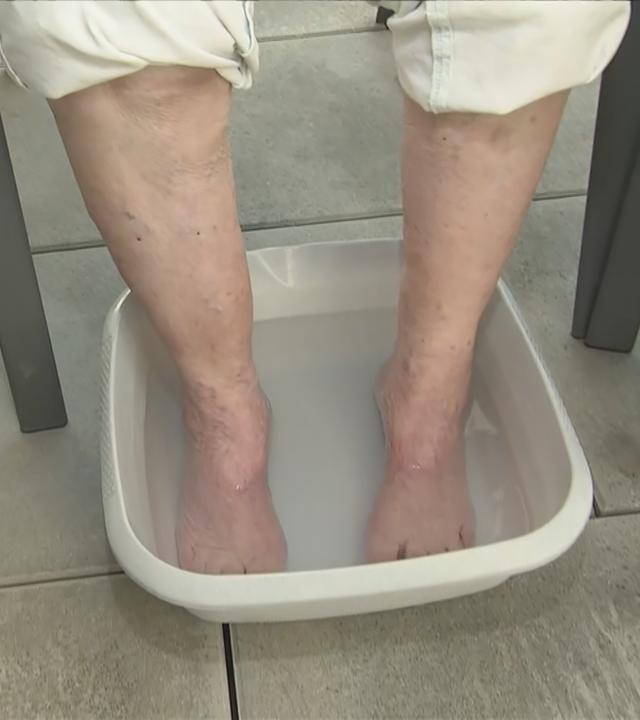 Nackte Füße in einer Schüssel mit Wasser