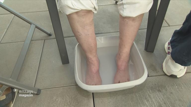 Nackte Füße in einer Schüssel mit Wasser