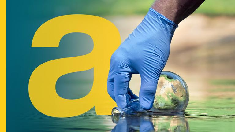 Eine Hand mit blauem Plastik-Handschuh, die mit einem Glaskolben Wasser aus einem Gewässer entnimmt.