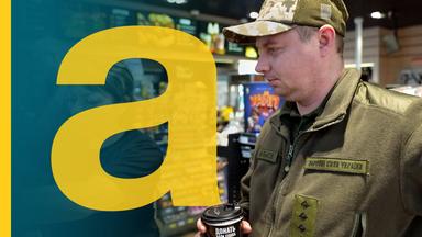 Ein ukrainischer Soldat steht in einer Tankstelle