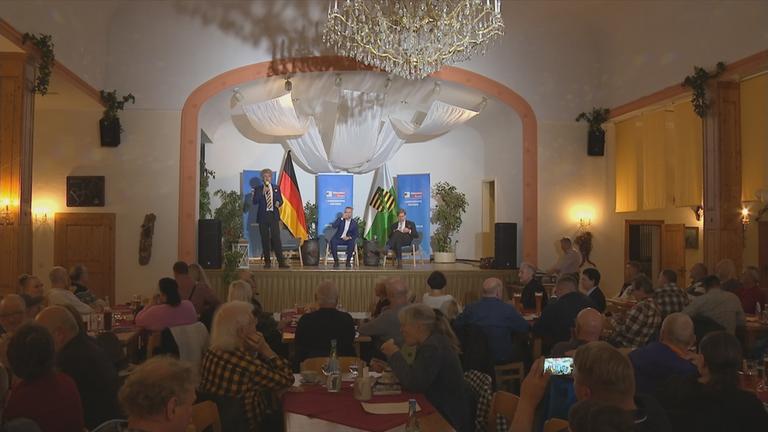 AfD Landes Parteitag mit Bühne auf der ein Bundestagsabgeordneter spricht