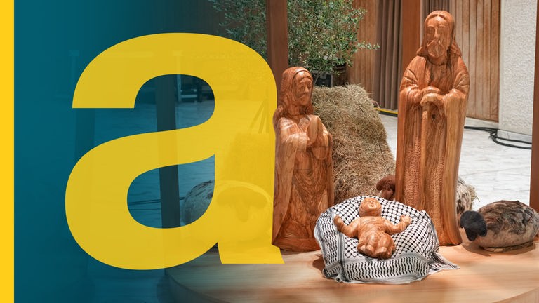 Eine Holzkrippe bestehend aus Josef, Maria und Jesus in der Krippe steht im Vatikan. Das Jesuskind liegt gebettet auf einem schwarz-weißen Tuch, einer Kufiya.