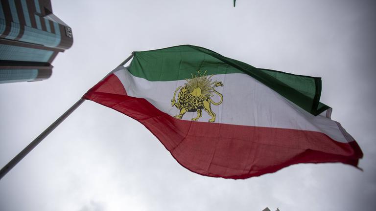 Eine iranische Flagge weht während einer Protestaktion gegen das derzeitige iranische Regime.