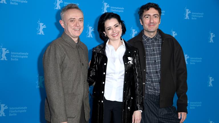 Die hauptdarsteller und der Regisseur von Gelbe Briefe vor einer blauen Wnad mit Berlinale Schriftzug