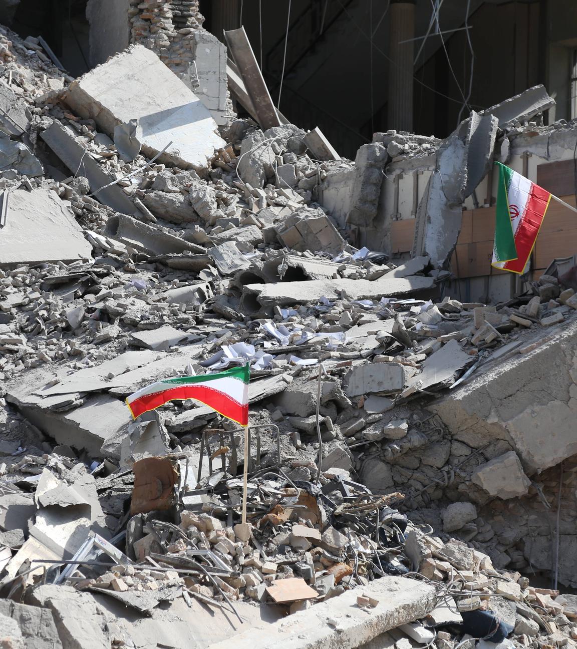 Iranische Flaggen wehen auf den Trümmern eines zerstörten Hauses
