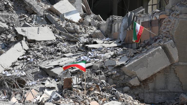 Iranische Flaggen wehen auf den Trümmern eines zerstörten Hauses