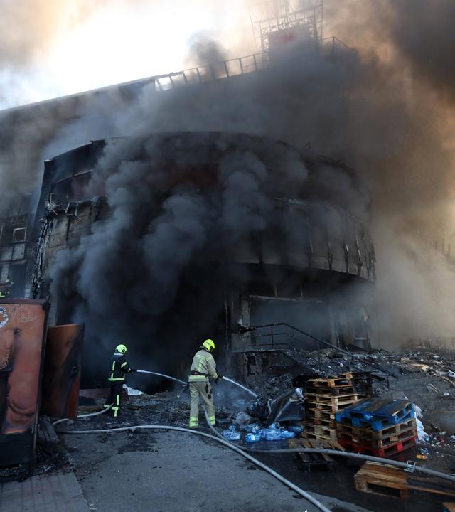 Feuerwehrleute versuchen das Feuer in einem Shoppingcenter in Kiew zu löschen.
