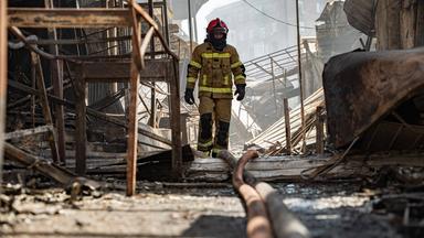 Ukrainischer Feuerwehrmann inmitten zestörter Gebäude