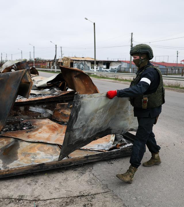 Soldaten räumen Trümmerteile von einer Straße.