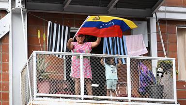 Eine Frau schwenkt eine venezolanische Flagge, während sie vom Balkon aus eine Demonstration junger Chavisten in Caracas am 8. Januar 2026 beobachtet, die die Freilassung des gestürzten venezolanischen Präsidenten Nicolas Maduro und seiner Frau Cilia Flores fordern, die am 3. Januar entführt und nach New York gebracht wurden, um sich dort wegen Drogen- und Waffenhandels vor Gericht zu verantworten.