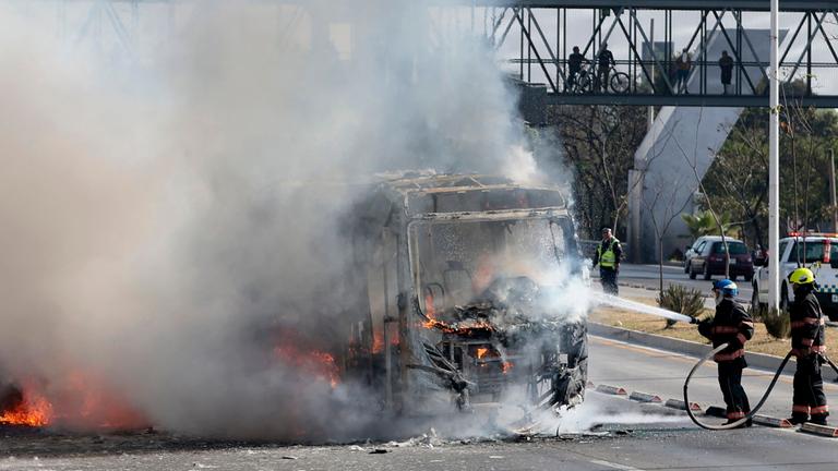 Feuerwehrleute sind im Einsatz, nachdem ein Bus von organisierten kriminellen Gruppen in Brand gesetzt wurde, als Reaktion auf eine Operation in Jalisco zur Festnahme einer hochrangigen Zielperson, auf einer der Hauptstraßen in Zapopan, Bundesstaat Jalisco, Mexiko, am 22. Februar 2026. Bewaffnete Zivilisten blockierten mehrere Straßen im Bundesstaat Jalisco im Westen Mexikos, nachdem die Bundeskräfte in der Stadt Tapalpa eine Operation durchgeführt hatten, wie lokale Behörden berichteten. Jalisco, wo vier Spiele der bevorstehenden Weltmeisterschaft 2026 ausgetragen werden, ist die Heimat des mächtigen Jalisco New Generation Cartel (CJNG) und wurde in den letzten Jahren von mehreren Gewaltausbrüchen erschüttert.