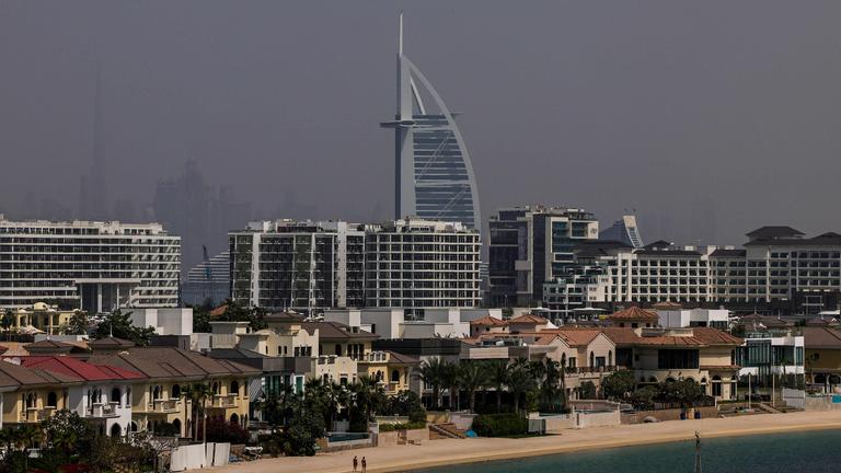 Der Strand am Palm Jumeirah in Dubai ist bis auf zwei Menschen leer. Im Hintergrund steht das Burj al Arab 