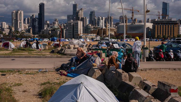 Vertriebene sitzen vor ihren Zelten in einem inoffiziellen Lager, das an der Küste von Beirut errichtet wurde