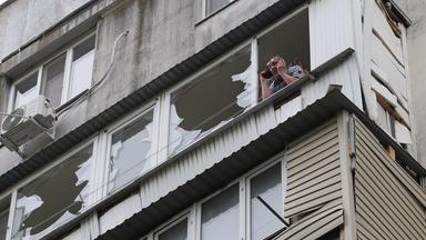 Ein Anwohner telefoniert mit seinem Handy, während er auf dem beschädigten Balkon eines Wohnhauses steht, das bei einem Luftangriff in Odessa am 13. Mai 2026 im Zuge der russischen Invasion in der Ukraine beschädigt wurde.