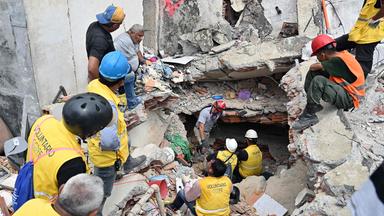 Rescuers working at the site of a collapsed building ask for silence in an attempt to listen to possible survivors, in Caraballeda, La Guaira state, Venezuela, on July 2, 2026,. More than a week after the earthquakes struck, there is little chance of finding additional survivors from the two earthquakes that killed nearly 2,300 people, destroyed entire residential buildings, and left tens of thousands missing.