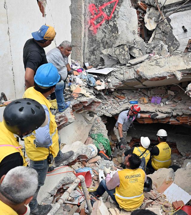 Rescuers working at the site of a collapsed building ask for silence in an attempt to listen to possible survivors, in Caraballeda, La Guaira state, Venezuela, on July 2, 2026,. More than a week after the earthquakes struck, there is little chance of finding additional survivors from the two earthquakes that killed nearly 2,300 people, destroyed entire residential buildings, and left tens of thousands missing.