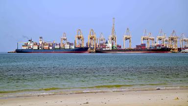 Am 14. Juli 2026 liegen Schiffe an einem Kai des Khor-Fakkan-Containerterminals vor Anker, dem einzigen natürlichen Tiefseehafen der Region und einem der wichtigsten Containerhäfen im Emirat Sharjah am Golf von Oman. Teheran kündigte am 12. Juli die Sperrung der Straße von Hormus an und feuerte Raketen und Drohnen auf seine Nachbarn am Golf ab – als Vergeltung für neue US-Angriffe nach einem Angriff iranischer Streitkräfte auf ein Handelsschiff, das von seiner Besatzung in Flammen zurückgelassen worden war.