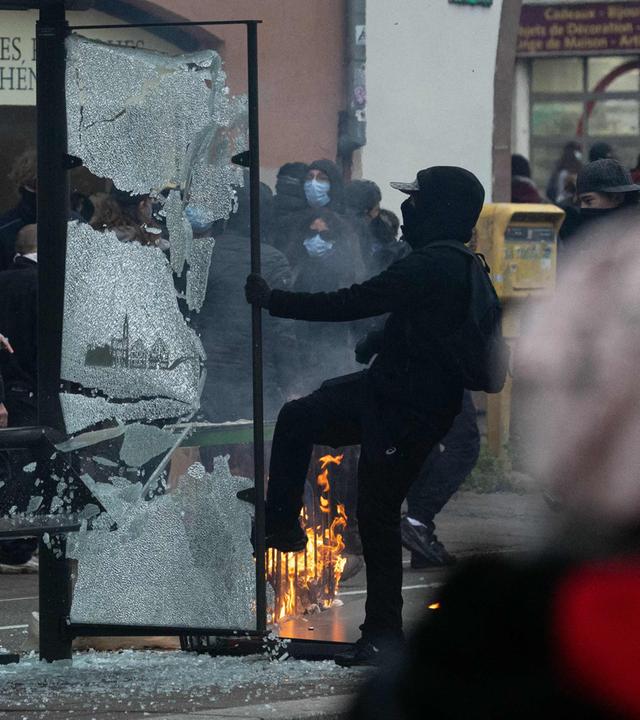 Ein Demonstrant zerschlägt während einer Demonstration für Kaufkraft, den Erhalt öffentlicher Dienstleistungen sowie steuerliche und soziale Gerechtigkeit am 24. Oktober 2026 in Straßburg im Osten Frankreichs die Scheibe einer Bushaltestelle. Die Demonstration fand im Rahmen eines landesweiten Mobilisierungsaufrufs statt, an dem ehemalige Mitglieder der „Gelbwesten“-Bewegung, Gewerkschaften sowie Schüler und Studenten teilnahmen. Proteste von Schülern gegen die Lernbedingungen lösten eine Bewegung aus, die sich seitdem landesweit ausgebreitet hat und durch die allgemeine Wut über die steigenden Lebenshaltungskosten angeheizt wird. Am 24. Oktober 2026 werden etwa 70.000 Sicherheitskräfte im Einsatz sein, erklärte der Innenminister auf einer Pressekonferenz und warnte davor, dass in den sozialen Medien Aufrufe zu Gewalt und Plünderungen kursierten.