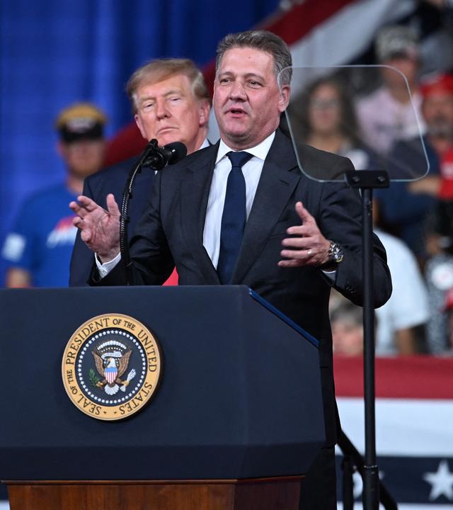 US-Präsident Donald Trump schaut zu, während Gernot Dollner, Vorstandsvorsitzender der Audi AG, am 24. Oktober 2026 bei einer Wahlkampfveranstaltung im Vorfeld der Zwischenwahlen im Guardian Centers of Georgia in Perry, Georgia, eine Rede hält. Präsident Trump reist durch das Land, um den Republikanern in knappen Wahlkämpfen im Vorfeld der Zwischenwahlen Rückenwind zu geben.