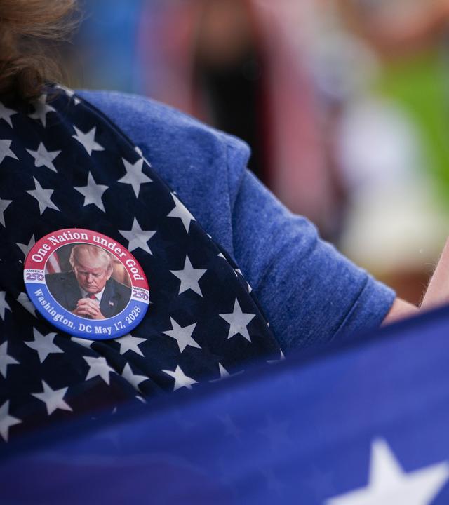 Eine Person trägt eine Anstecknadel mit dem Bildnis von Präsident Donald Trump bei „Rededicate 250“, einer überwiegend konservativ-christlichen Gebetsversammlung zu Ehren des 250-jährigen Bestehens der Vereinigten Staaten, auf der National Mall am Sonntag, dem 17. Mai 2026, in Washington
