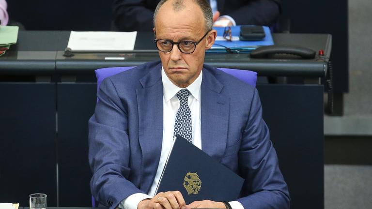 Berlin, Deutschland, 18.03.2026: Deutscher Bundestag: 64. Bundestagssitzung: Bundeskanzler Friedrich Merz (CDU) mit der Mappe fuer das Redeskript seiner Regierungserklaerung