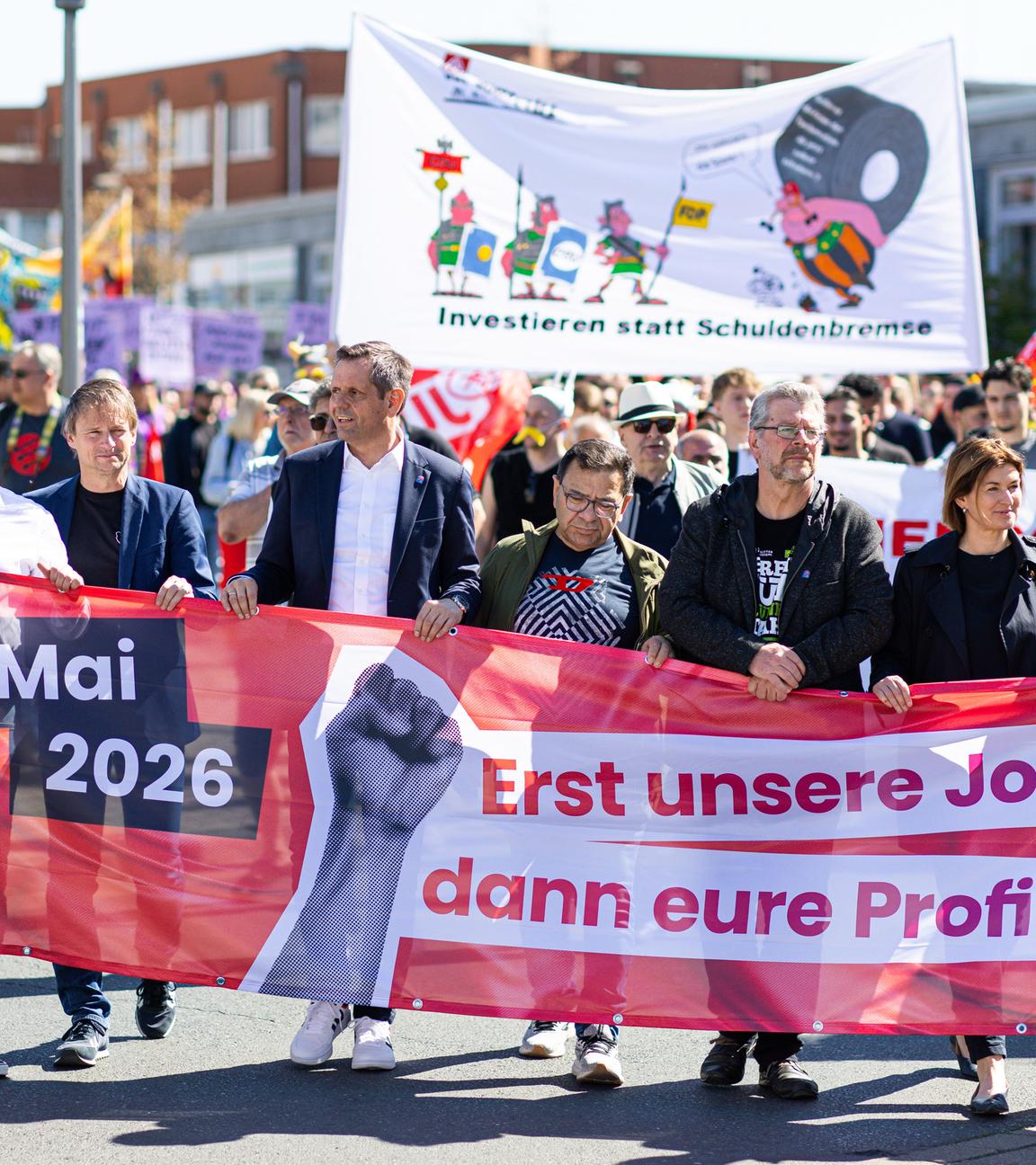 Olaf Lies (3.v.l,SPD), Ministerpräsident von Niedersachsen, hält zusammen mit anderen Teilnehmern einen Banner des Deutscher Gewerkschaftsbunds mit der Aufschrift: «1. Mai 2026; Erst unsere Jobs, dann eure Profite». Anlass sind bundesweite Kundgebungen der Gewerkschaften zum internationalen Tag der Arbeit.