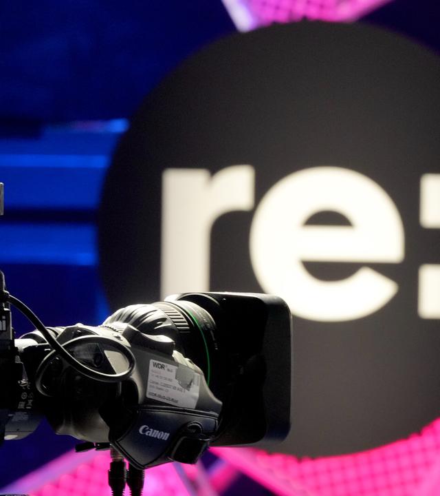 Eine TV-Kamera ist während der Medienkonferenz re:publica 26 im Stage 5 vor dem Logo «re:» aufgebaut.