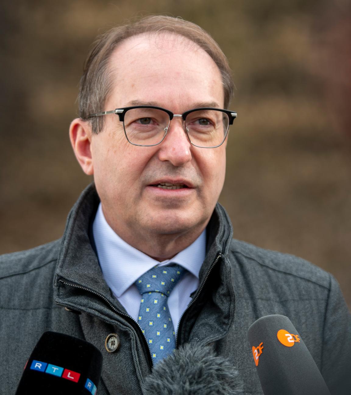 22.02.2026, Bayern, Peißenberg: Bundesinnenminister Alexander Dobrindt (CSU) geht an einer Fernsehkamera vorbei. Er äußerte sich zu den Plänen, Asylbewerber schneller in Arbeit zu bringen.