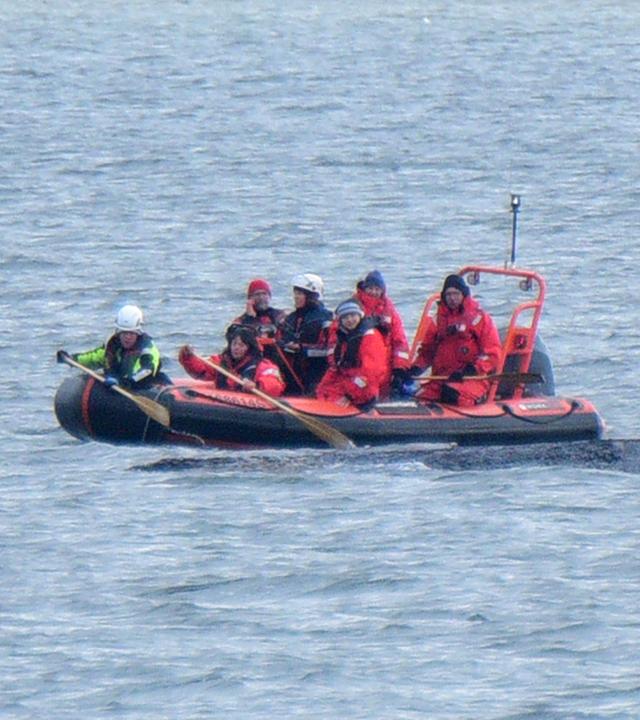 Ein Boot von Greenpeace fährt an einem in der Ostsee liegenden Wal entlang. Der vor rund einer Woche beim Timmendorfer Strand an der Ostseeküste gestrandete Wal liegt aktuell vor Wismar.